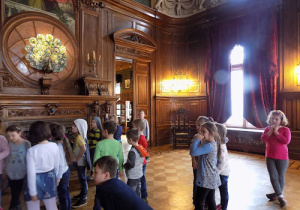 Dzieci obserwują ozdobione wnętrza pałacu.