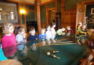 Dzieci obserwują eksponat w szklanej gablocie.