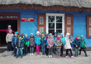 Dzieci pozują przed wejściem do budynku Szkoły Podstawowej w Łaźnikach