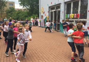Dzieci tańczą w parach w kole