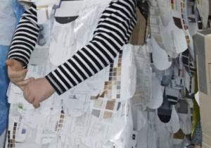 chłopiec w stroju z kartonu i gazet