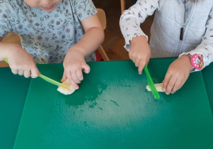 Dziewczynki kroją owoce plastikowymi nożami