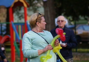 Kobieta w rękach trzyma skręconego balona.