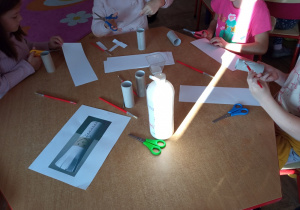Dzieci pracują w zespole twórczym. Wykonują pracę plastyczną - kucharza z rolki od papieru toaletowego.