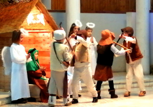 Czterej pastuszkowie prezentują taniec, w tle widać szopkę, Józefa i anioły