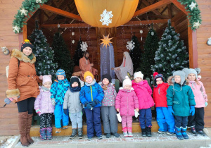 Dzieci z grupy czerwonej przy szopce bożonarodzeniowej.