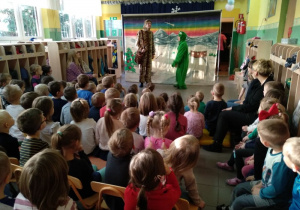 Dzieci z widowni patrzą na aktorów przebranych za żabę i tygrysa.