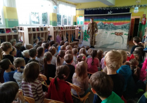 Dzieci oglądają występ tygryska, który stoi z lewej strony sceny.