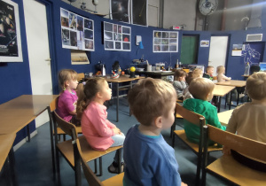Przedszkolaki oglądają prezentacje przed pokazem w planetarium.