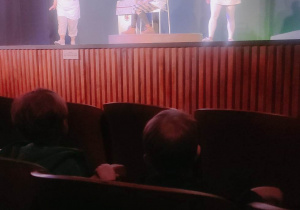 Przedszkolaki oglądają przedstawienia ,,Doktor Nieboli'', na scenie aktorzy.