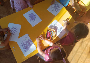 Dzieci wyklejają obrazek małymi karteczkami.