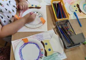 Dzieci tworzą portret kucharza z wykorzystaniem papierowych talerzyków, dorysowują elementy.