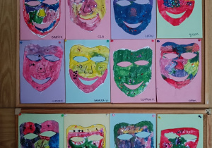 Prace wywieszone na tablicy - maski teatralne wykonane przez dzieci z grupy fioletowej