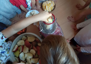 Dzieci przy stole robią sok