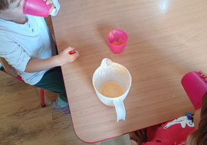 Dzieci piją soki przy stoliku