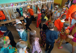 Dzieci w jesiennych strojach bawią się przy piosenkach z repertuaru dziecięcego.