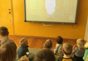 Dzieci oglądają film na tablicy interaktywnej.