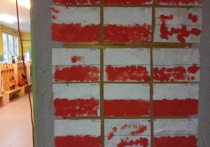 Na tablicy wywieszone prace dzieci - biało-czerwone flagi pomalowane farbą.