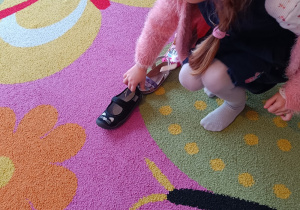 Dziewczynka kładzie swój but w "wyścigu butów".