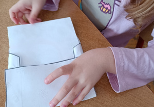 Dziewczynka wkłada list do koperty.