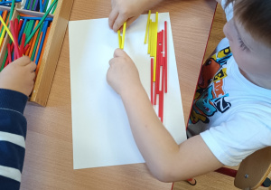Cchłopiec układa flagę Łodzi z darów Froebla.