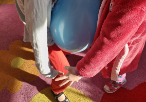 Dzieci biorą udział w konkursie - tańczą trzymając brzuchami balon.