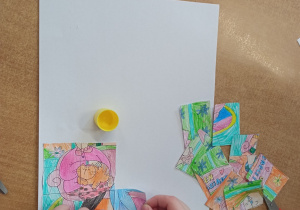 Dzieci przyklejają pocięty obrazek na kartkę.