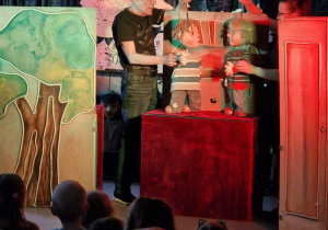 Na scenie kobieta i mężczyzna trzymający lalki teatralne.