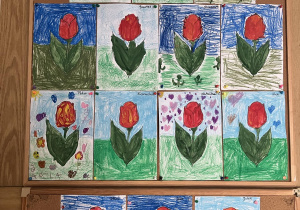 Na tablicy wywieszone prace dzieci - tulipany pokolorowane pastelami.