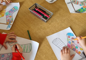 Dzieci kolorują dwie różne skarpetki.