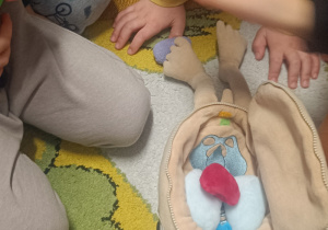 Dzieci siedzą wokół zabawki edukacyjnej -anatomicznej.