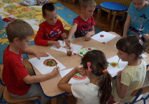 Dzieci malują farbami kropki.