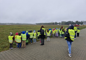 Dzieci obserwują start samolotu pasażerskiego.