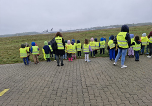 Dzieci obserwują start samolotu pasażerskiego.