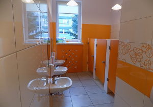 Łazienka grupy pomarańczowej - umywalki, okna, pomarańczowe drzwi do toalet