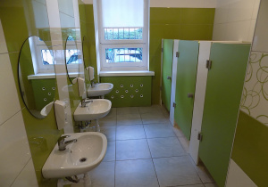 Łazienka grupy zielonej - umywalki, okna, zielone drzwi do toalet